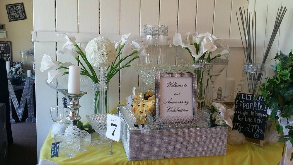 A table with flowers , candles , and a sign on it.