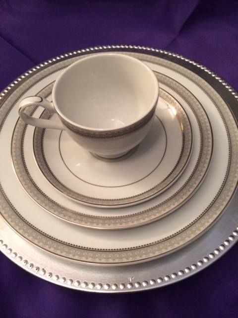 A stack of plates and a cup on a silver plate