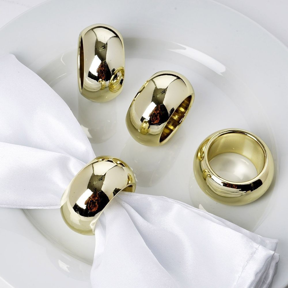 Four gold napkin rings are on a white plate