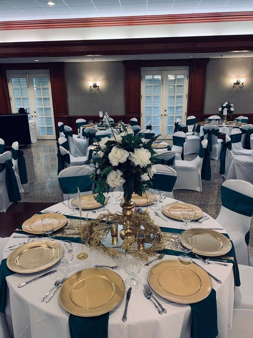 A large room with tables and chairs set up for a wedding reception.