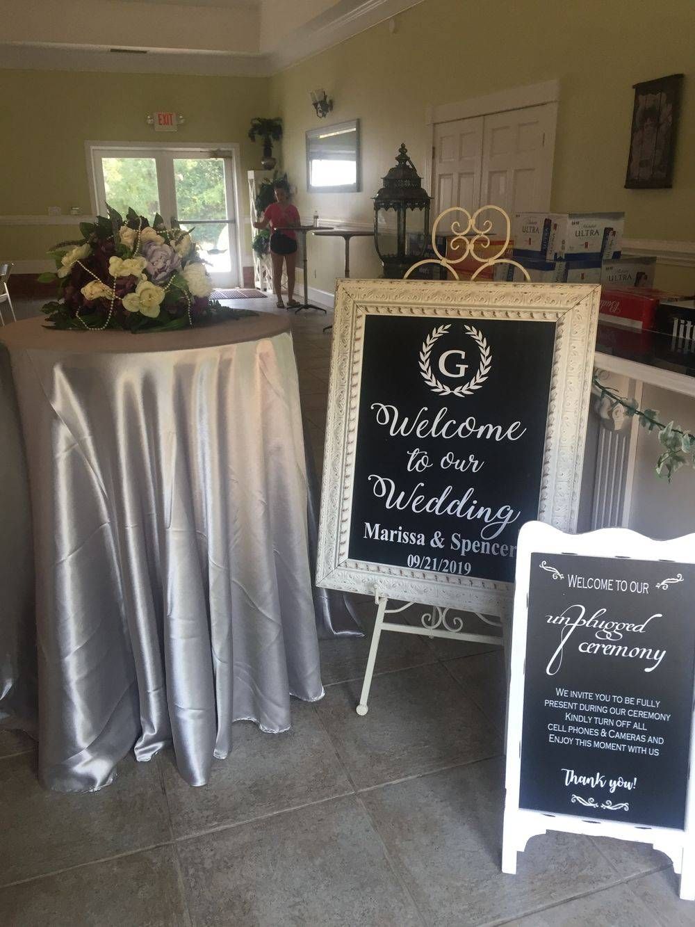A sign that says welcome to our wedding is on a table in a room.
