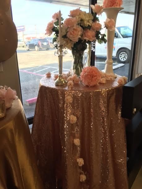 A table with a sequined tablecloth and flowers on it