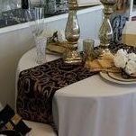 A table with a table runner and plates on it.
