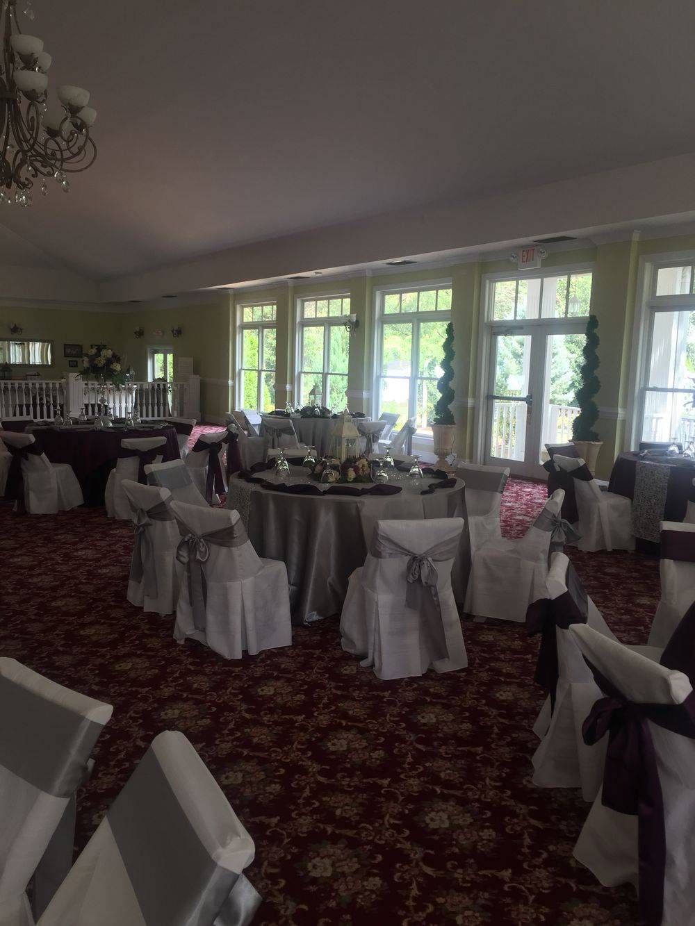 A large room with tables and chairs set up for a wedding reception.