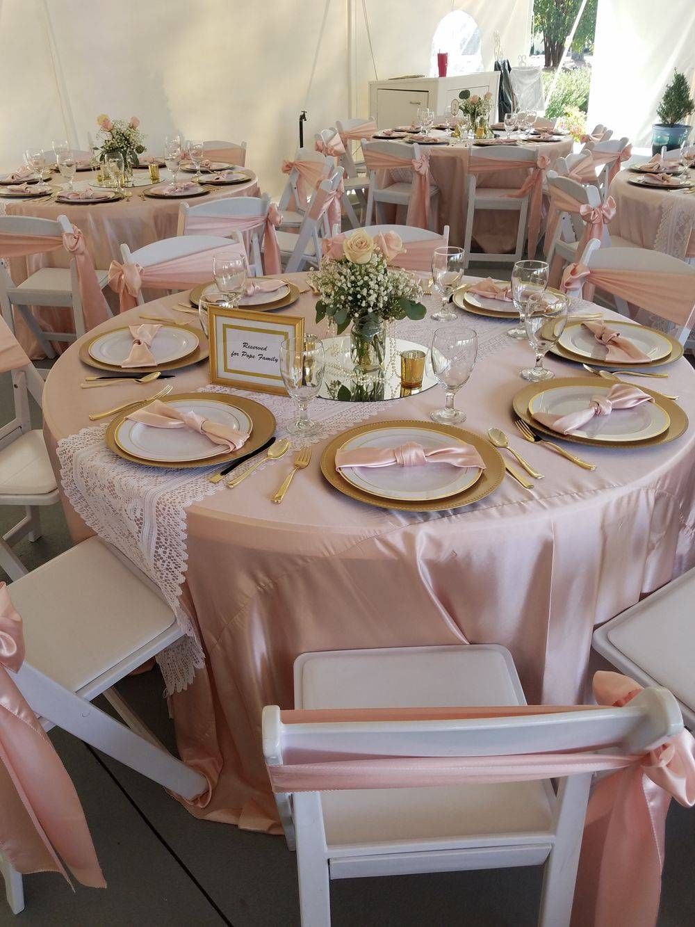 A table set up for a wedding reception with plates and utensils on it.