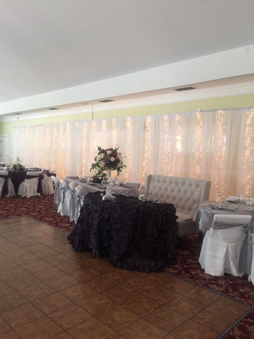 A large room with tables and chairs set up for a wedding reception.