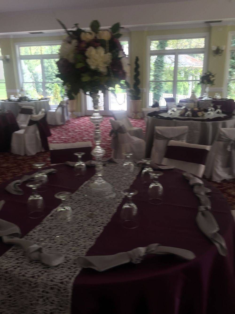 A room with tables and chairs set up for a wedding reception
