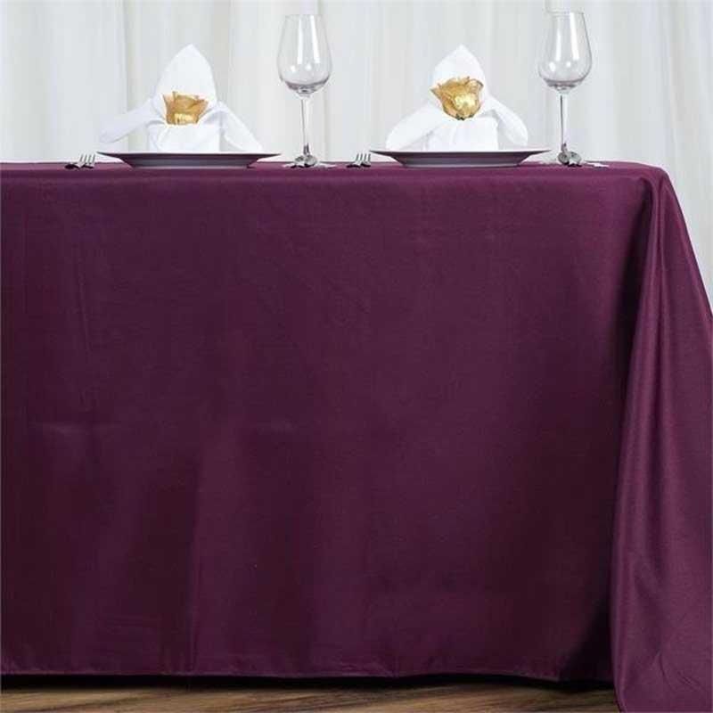 A table with a purple tablecloth and plates and glasses on it.
