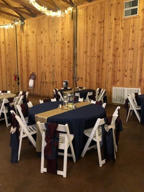 A room with tables and chairs set up for a wedding reception