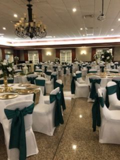 A large room with tables and chairs set up for a wedding reception.