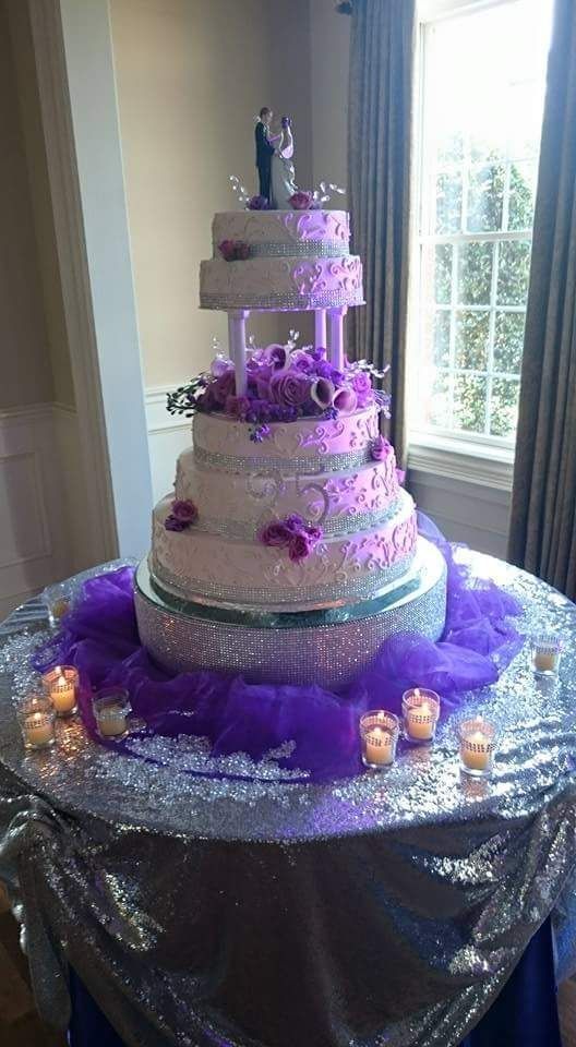 A wedding cake is sitting on top of a table with candles.