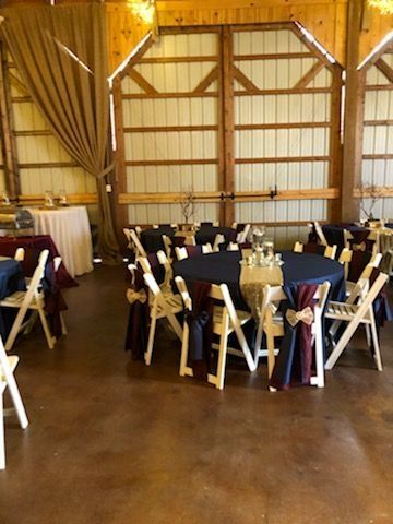 A room with tables and chairs set up for a wedding reception.