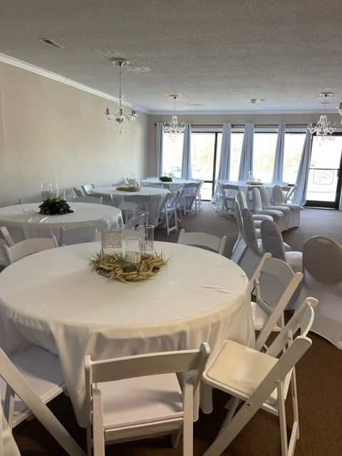 A room with tables and chairs set up for a wedding reception