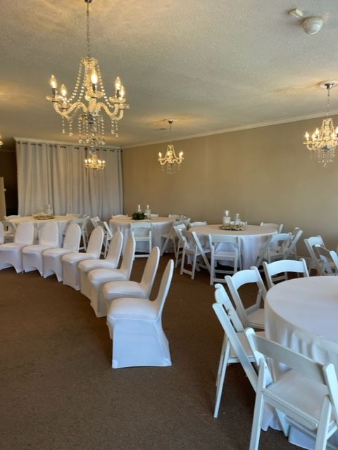 A room with tables and chairs and a chandelier
