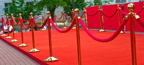 A row of red rope barriers on a red carpet
