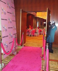 A pink carpet is leading to a room with tables and chairs.