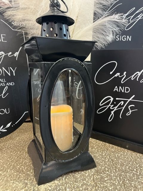 A black lantern with a candle inside of it