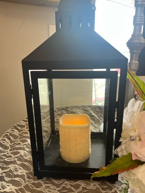 A black lantern with a candle inside of it