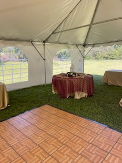 A tent with a table and a dance floor inside of it.