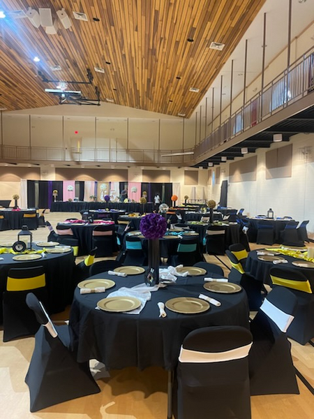 A large room with tables and chairs set up for a party