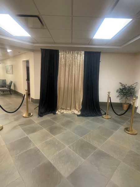 A room with black and gold curtains and rope barriers