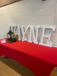 The word wayne is written in white letters on a red table cloth.