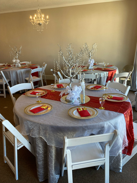 A room with tables and chairs set up for a wedding reception.