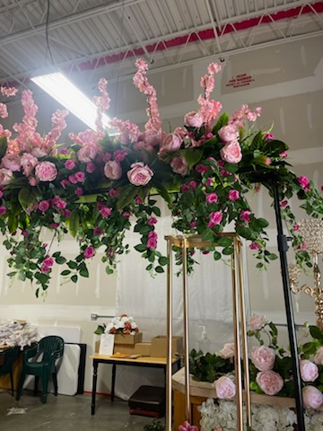 A room with a lot of pink flowers hanging from the ceiling.