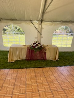 A table with flowers on it is under a tent.