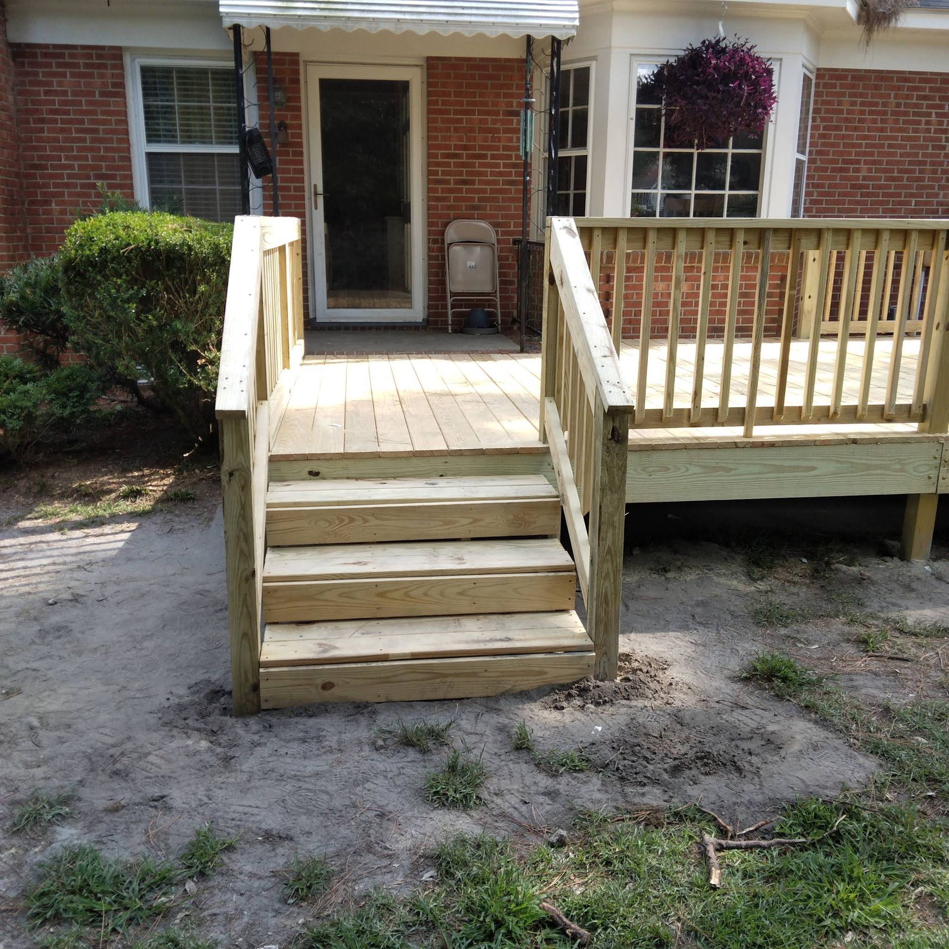 A brick house with a wooden deck and stairs