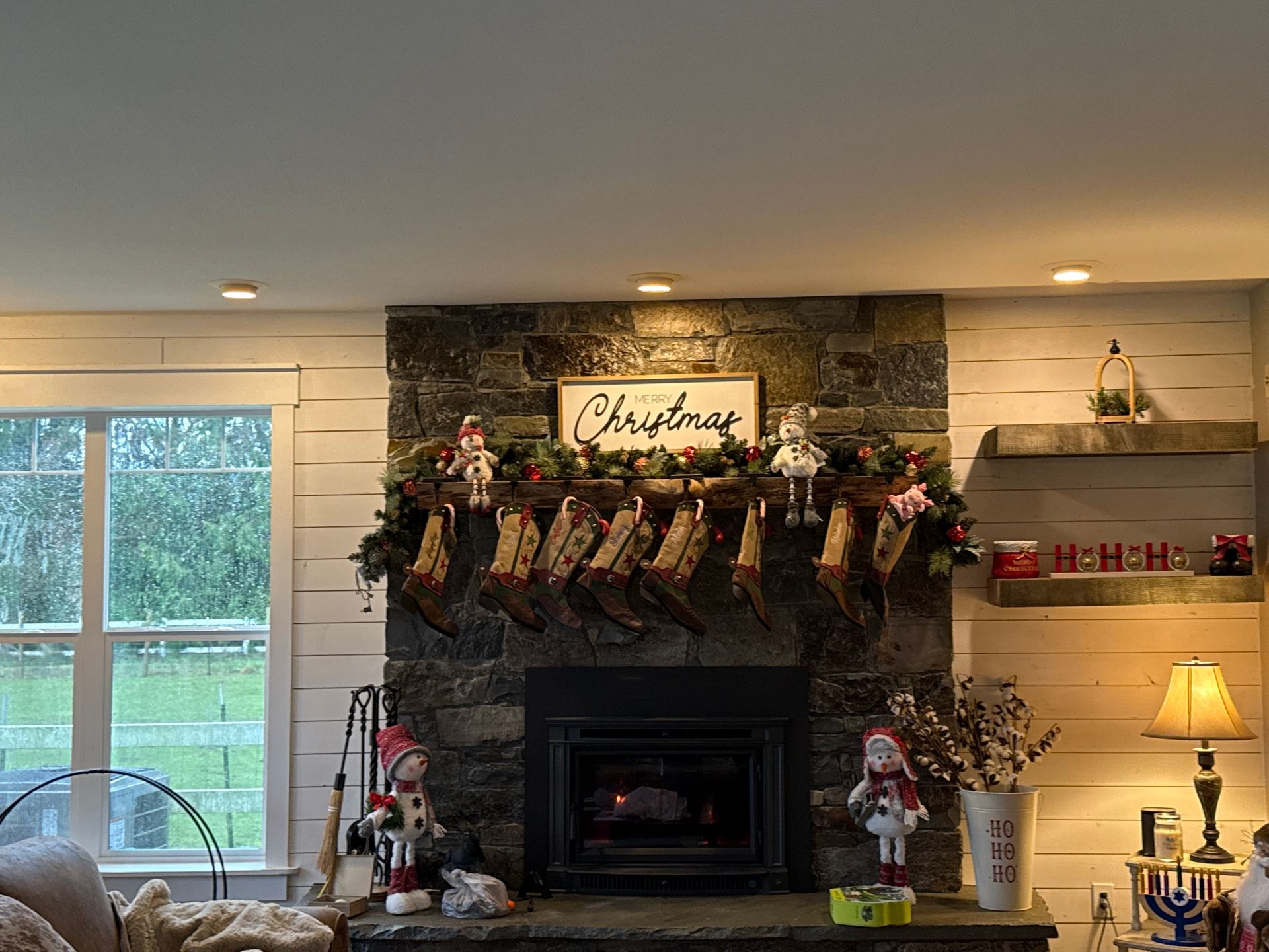 Stone fireplace with black firebox and wooden mantel.