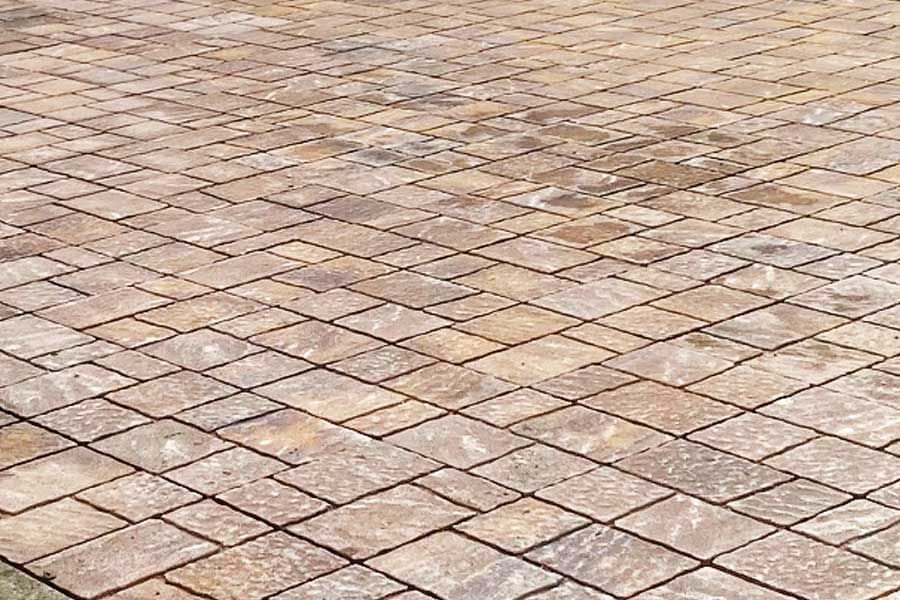 Brown and tan stone pavers arranged in a diamond pattern.