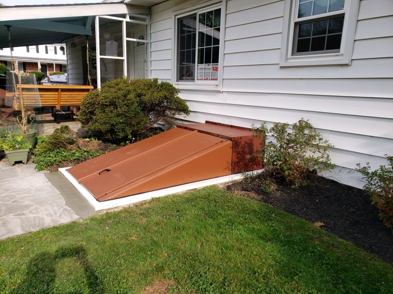 A white house with a brown door on the side of it.