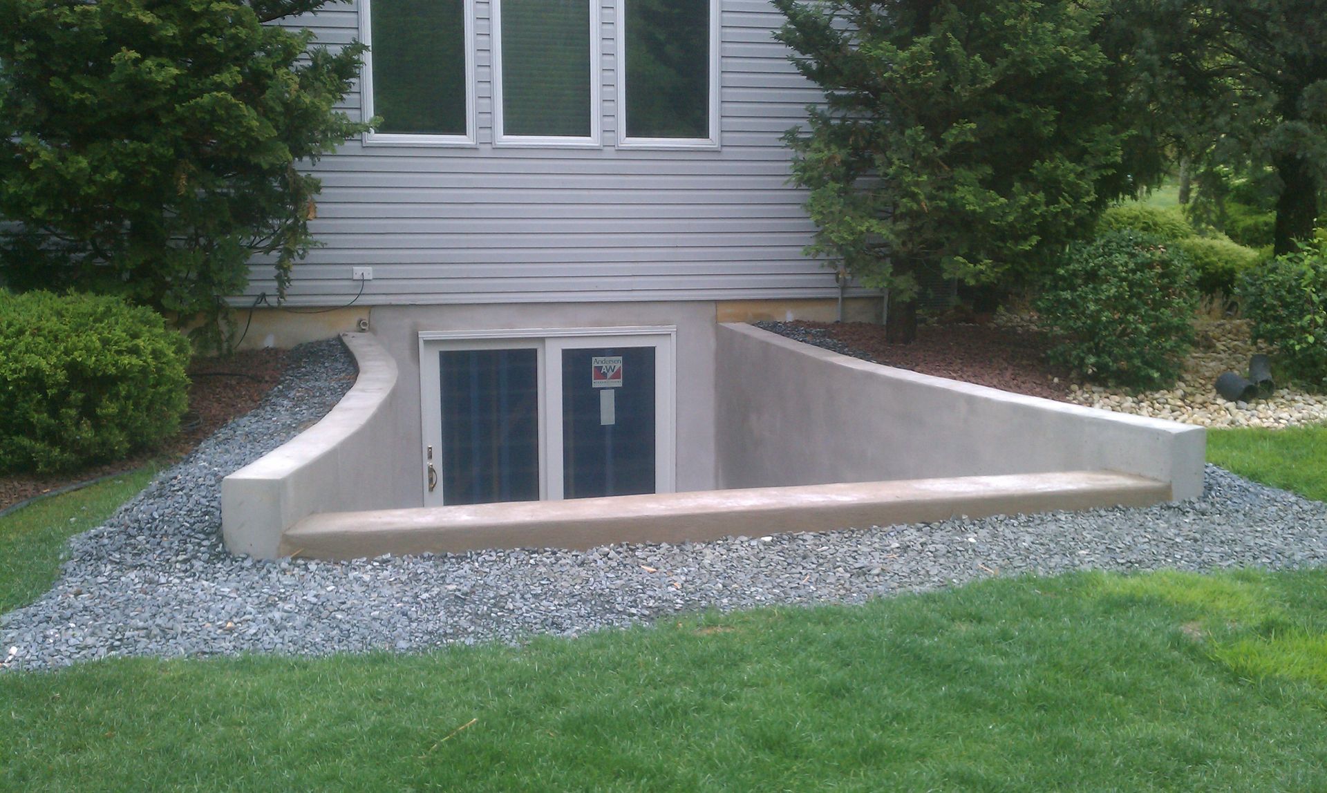 A house with a basement that has a door and a window
