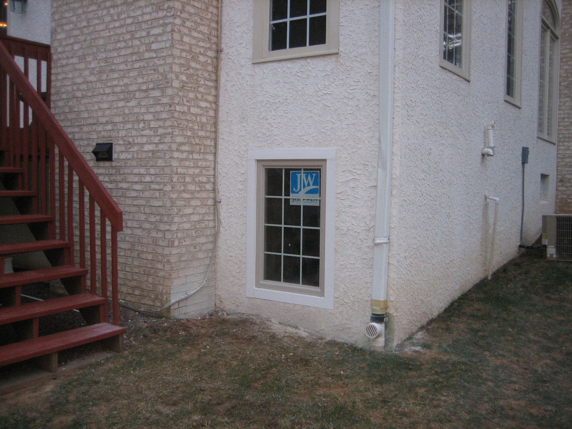 A white building with a window that says jw on it