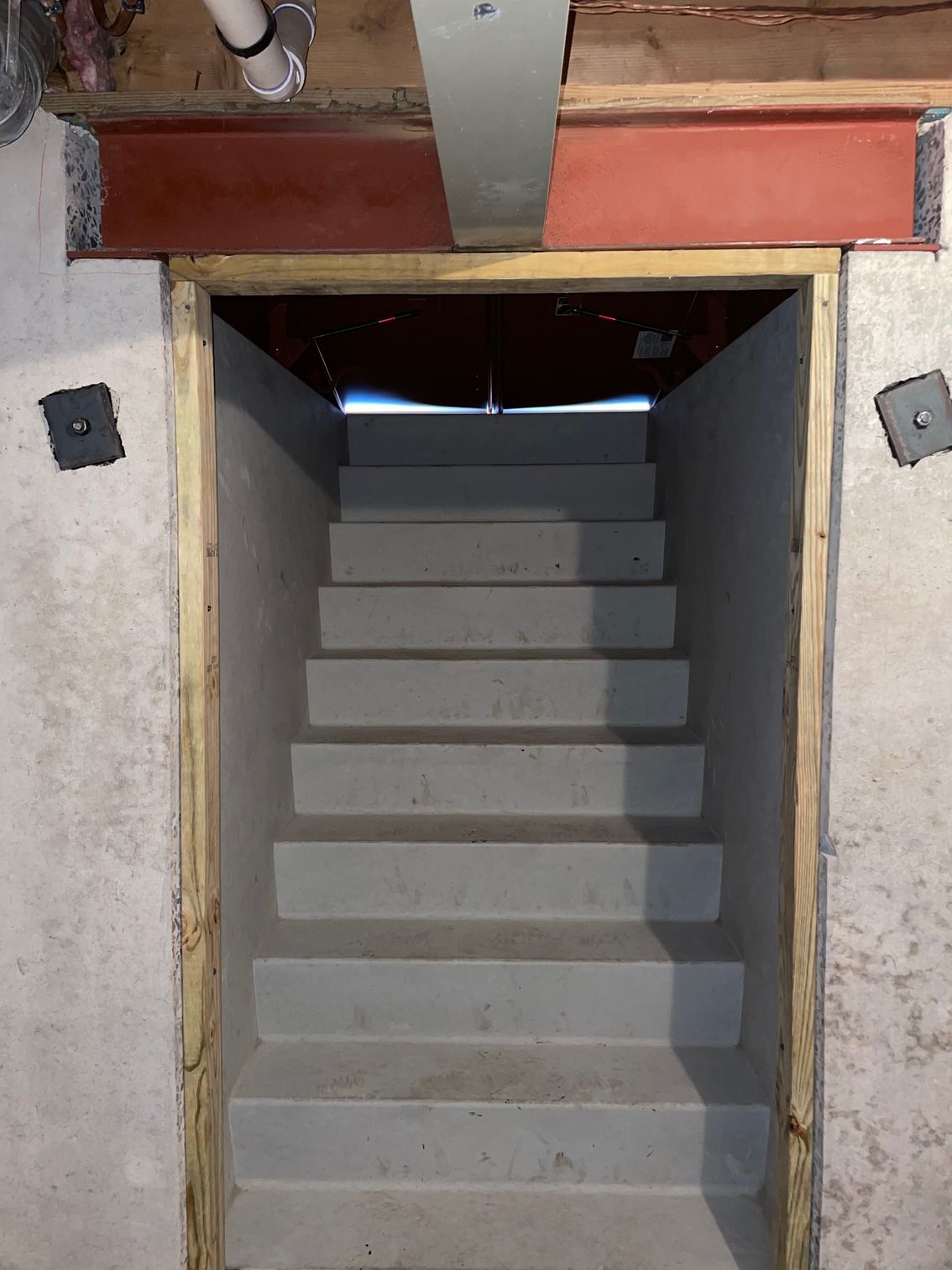 A set of stairs in a basement with a wooden frame