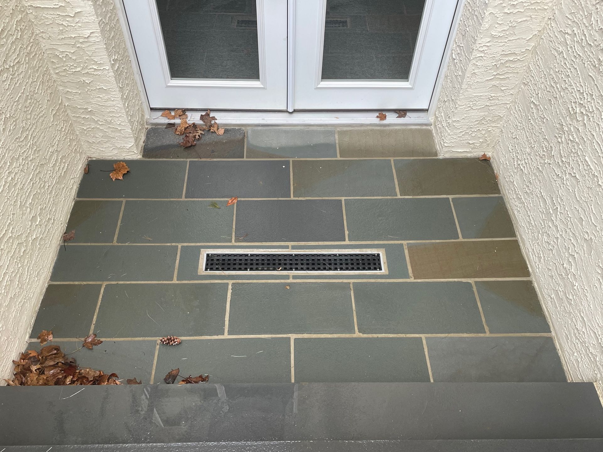 A tiled floor with a white door in the background