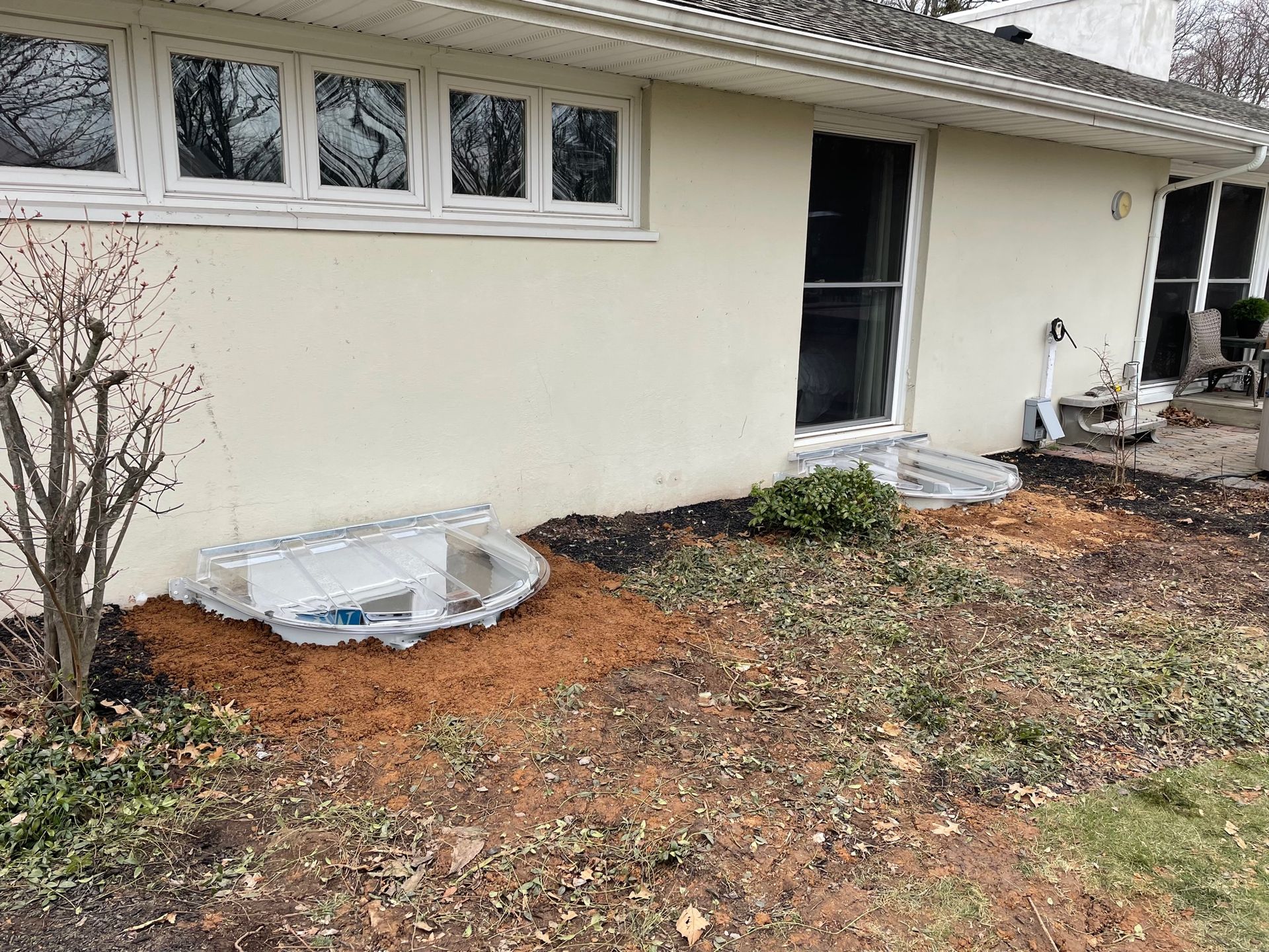 A white house with a well in the backyard.