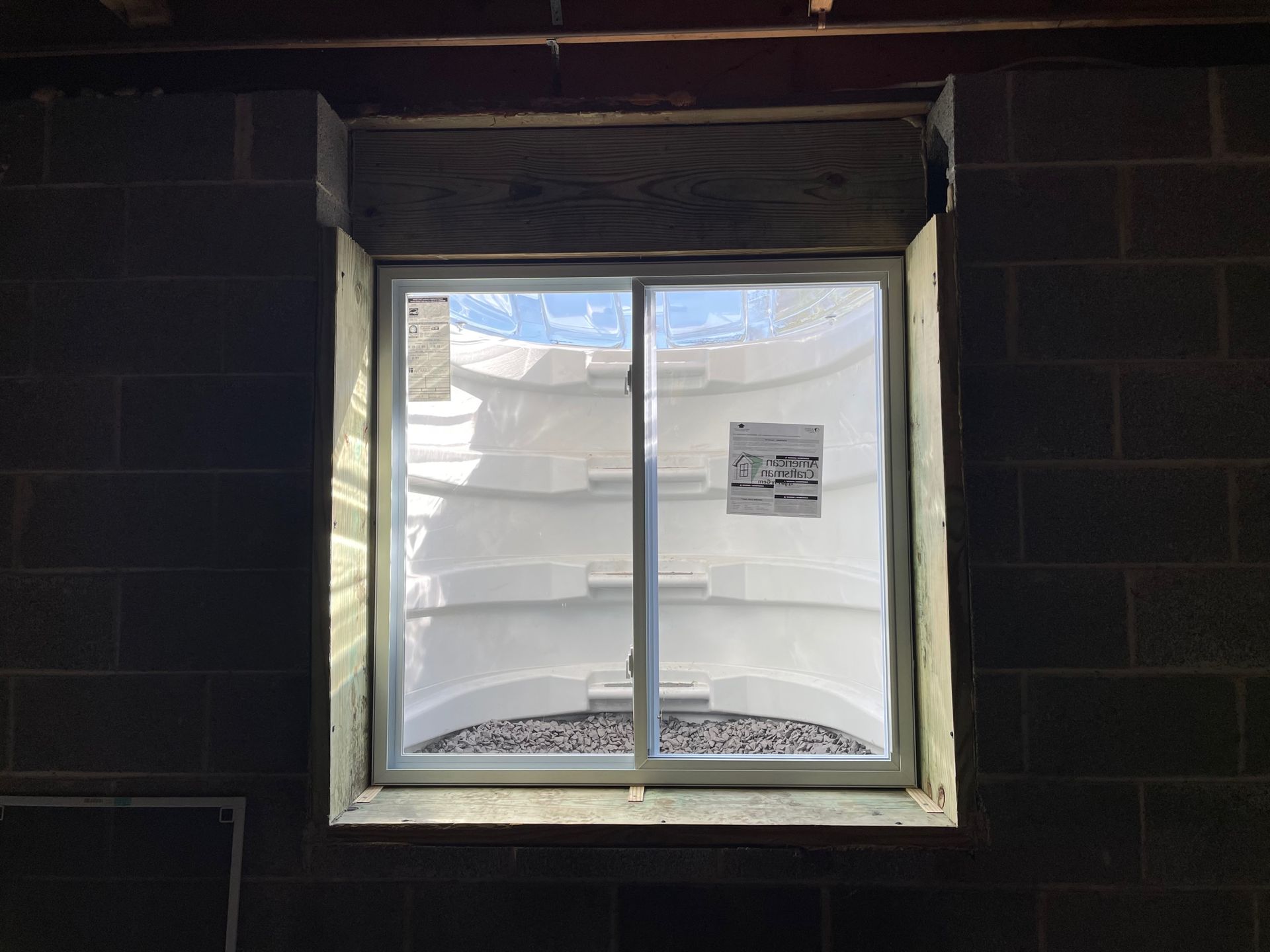 A window with a sliding glass door in a brick wall