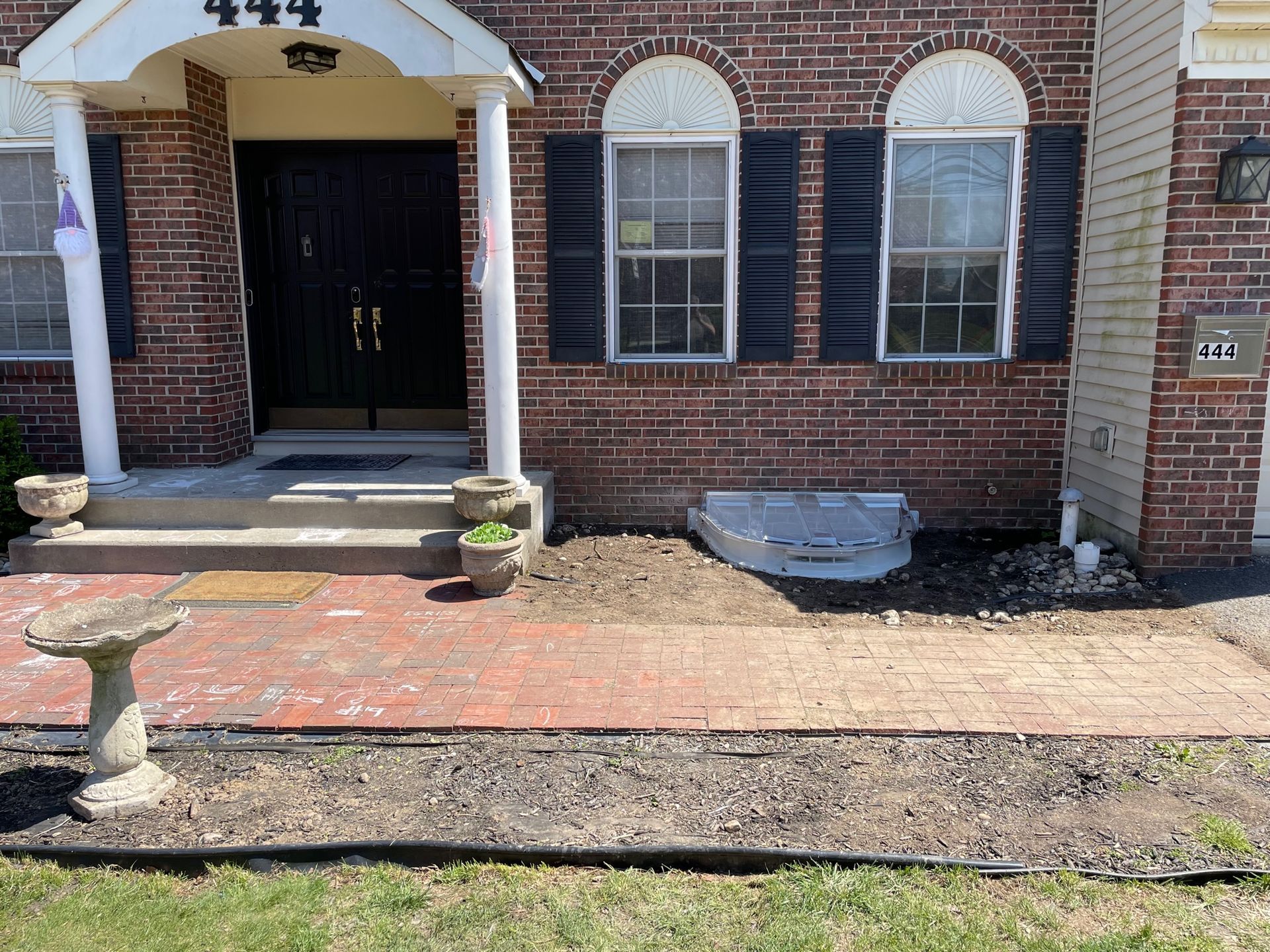 A brick house with a bird bath in front of it