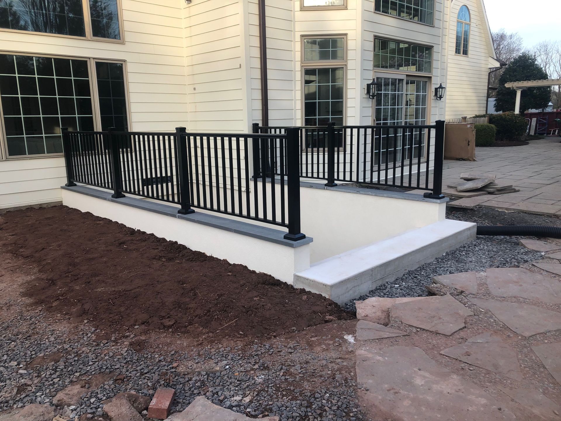 A white house with a black railing and a ramp