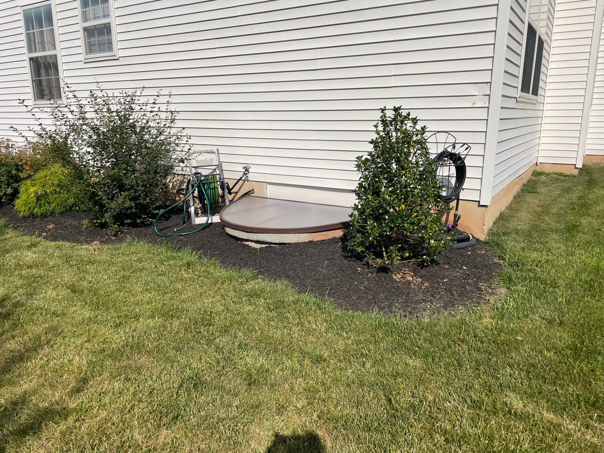 A white house with a hot tub in the backyard.