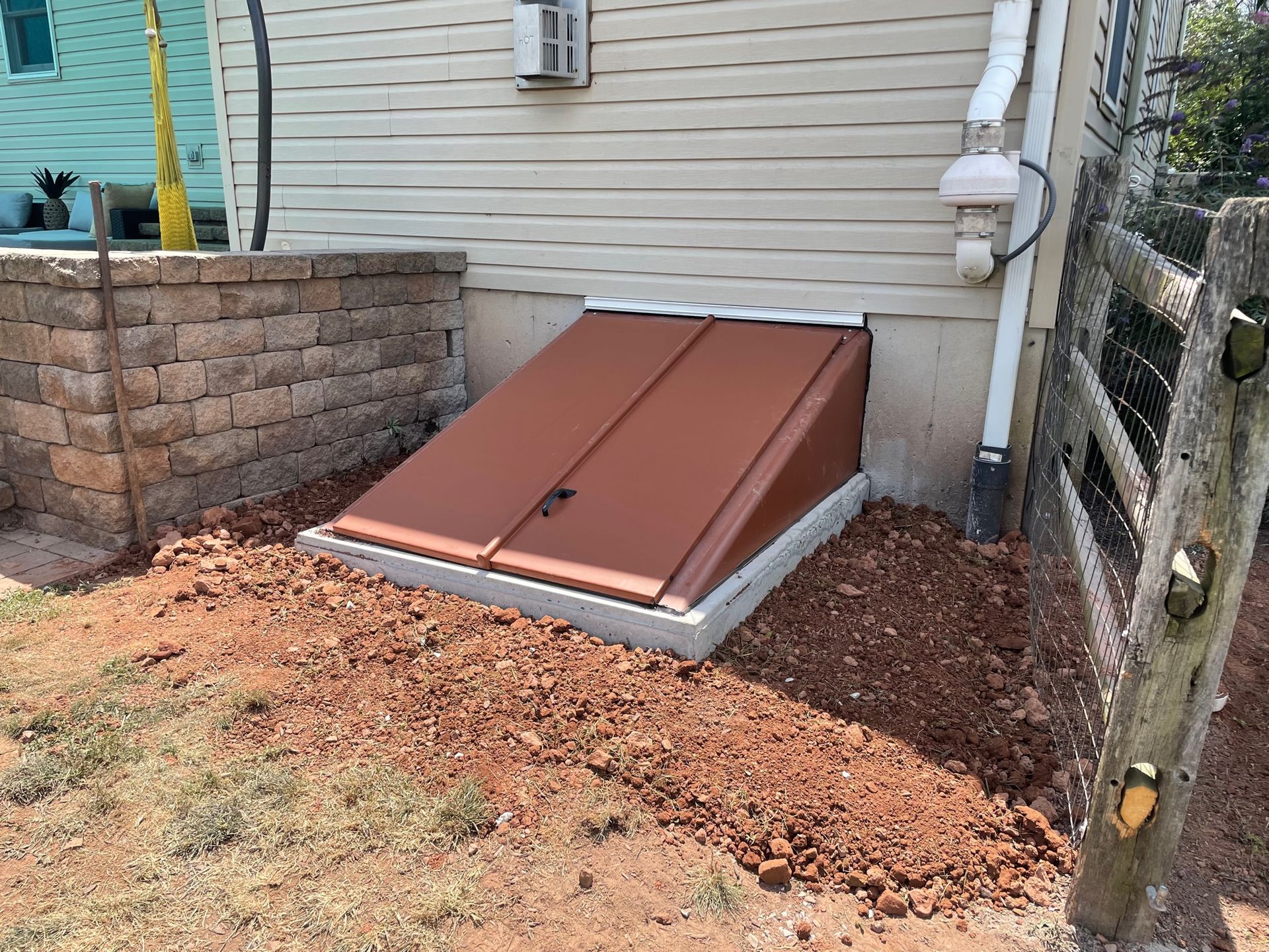 A brown door is sitting in the dirt next to a house.