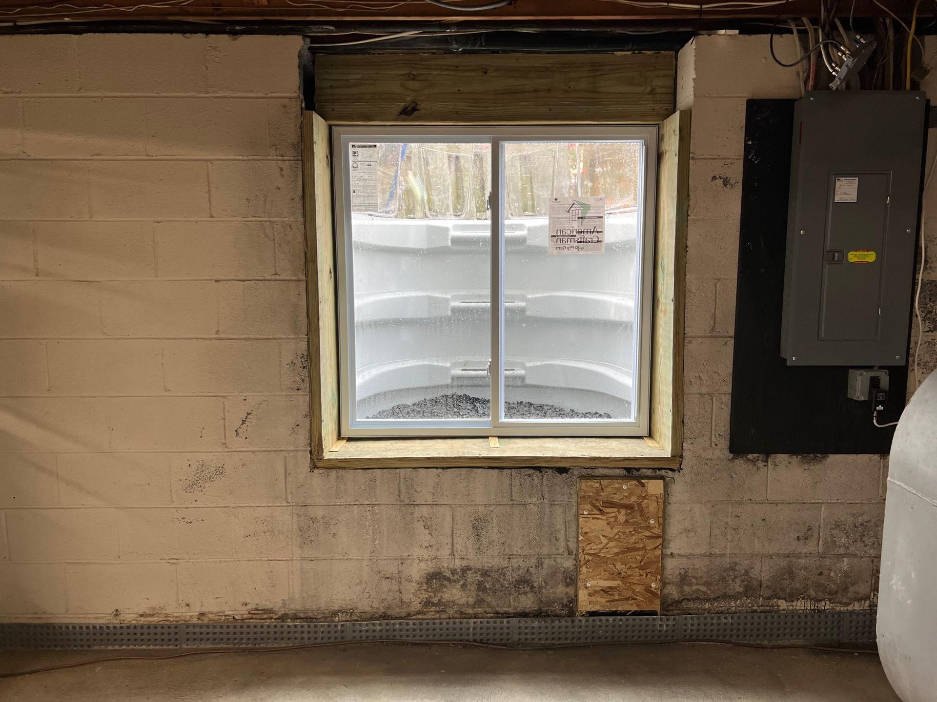 A window in a basement with a sliding glass door.