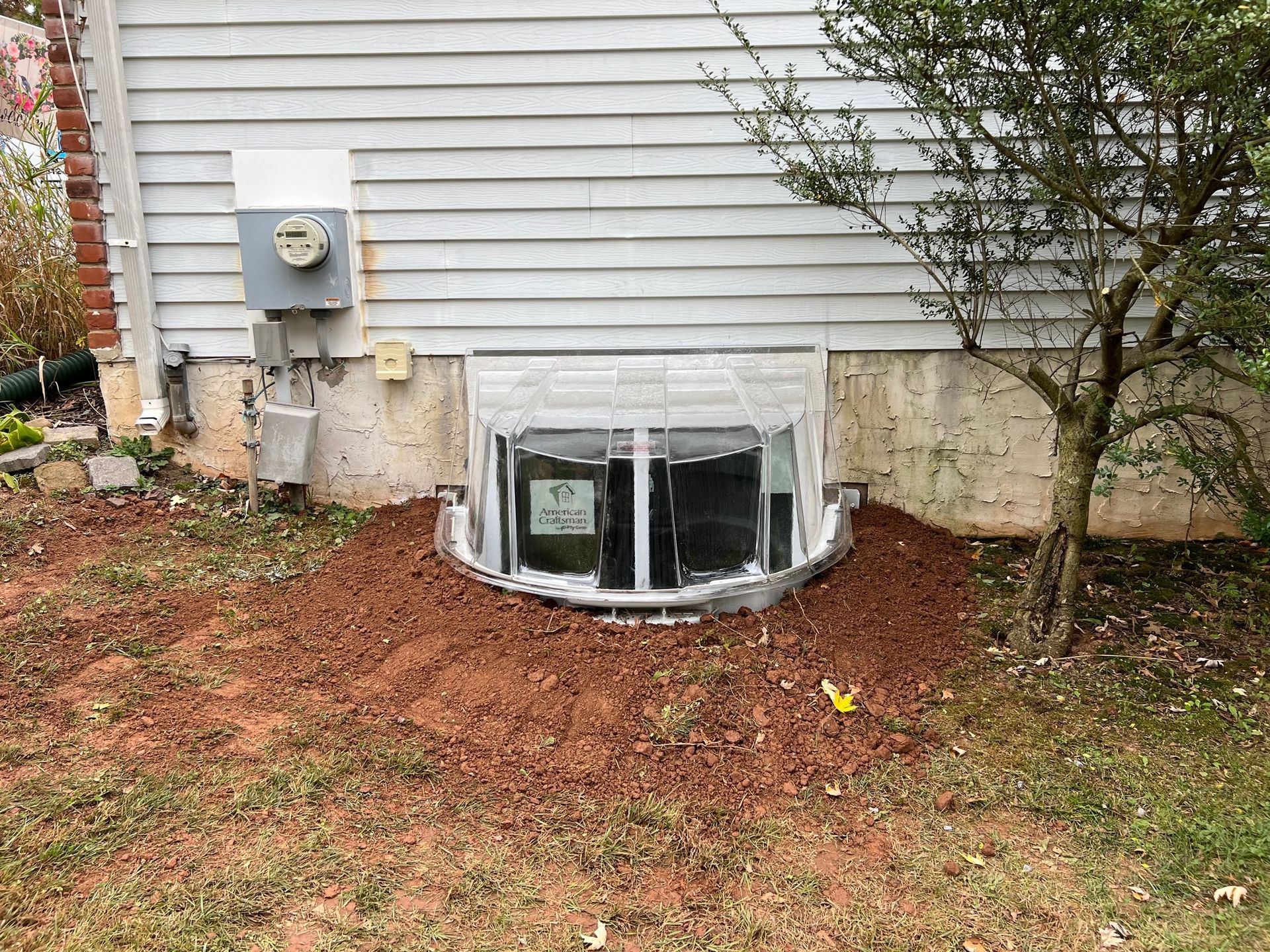 There is a window in the basement of a house.