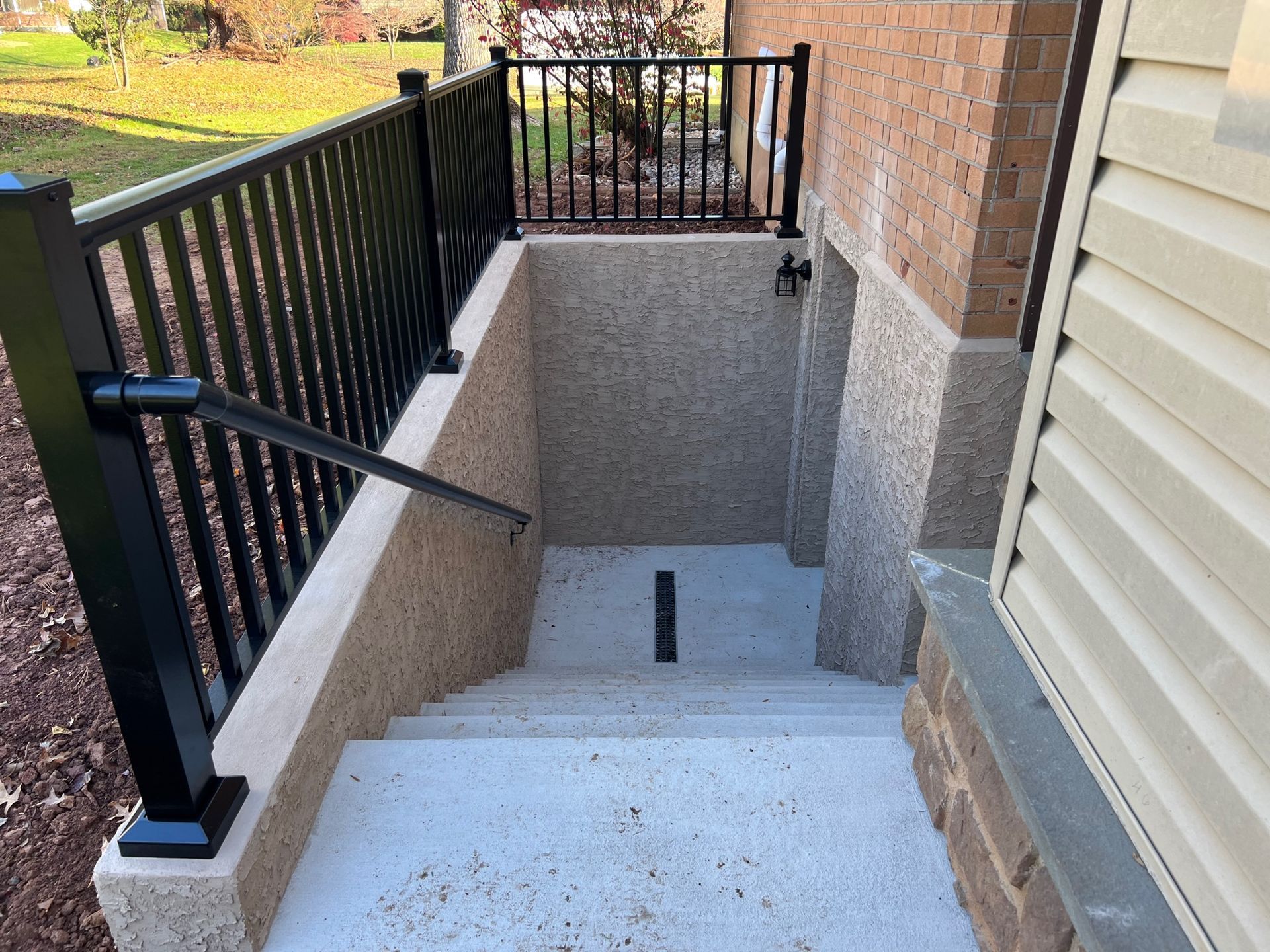 Stairs leading up to a basement with a black railing