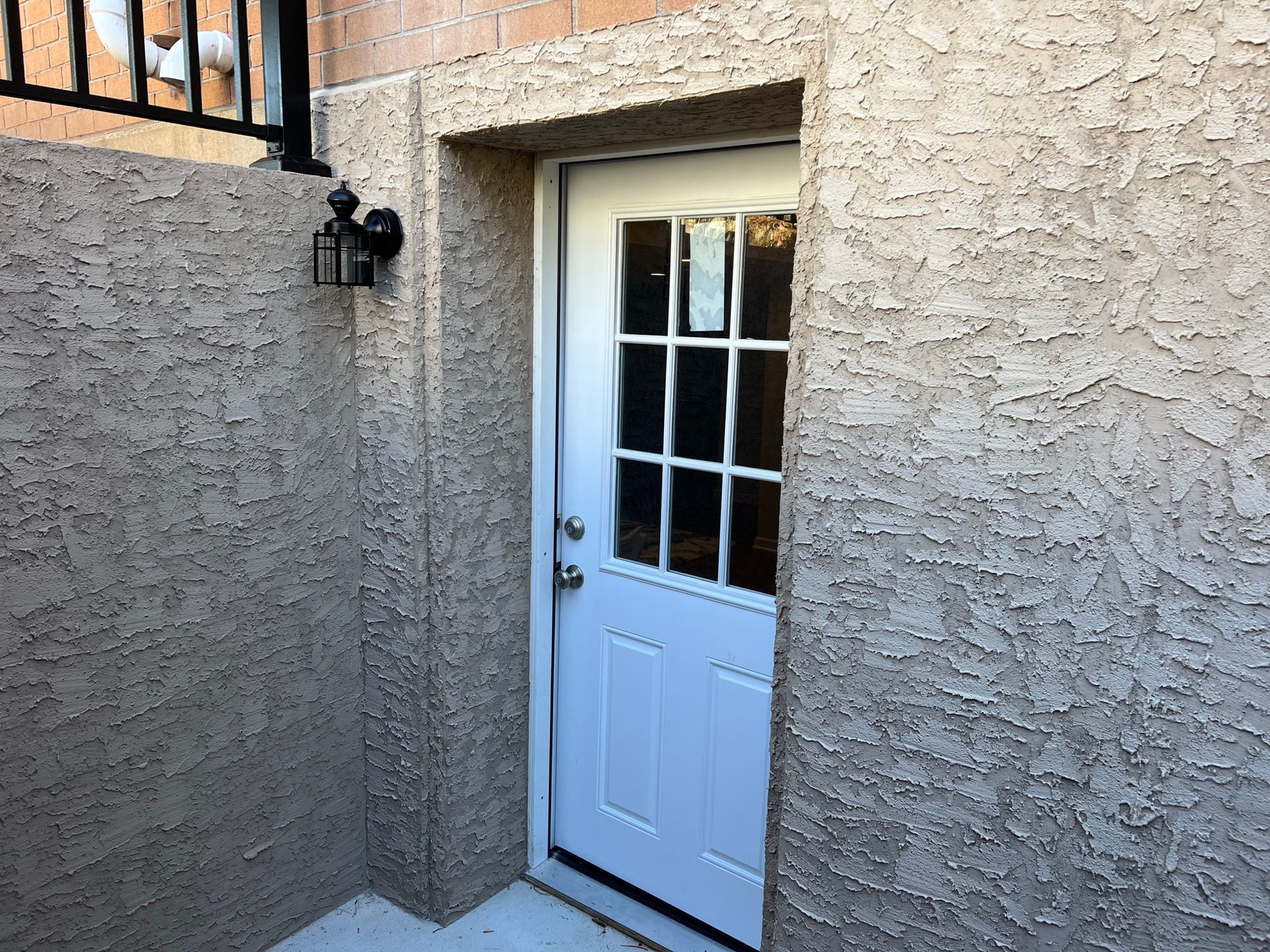 A white door is sitting on the side of a building.