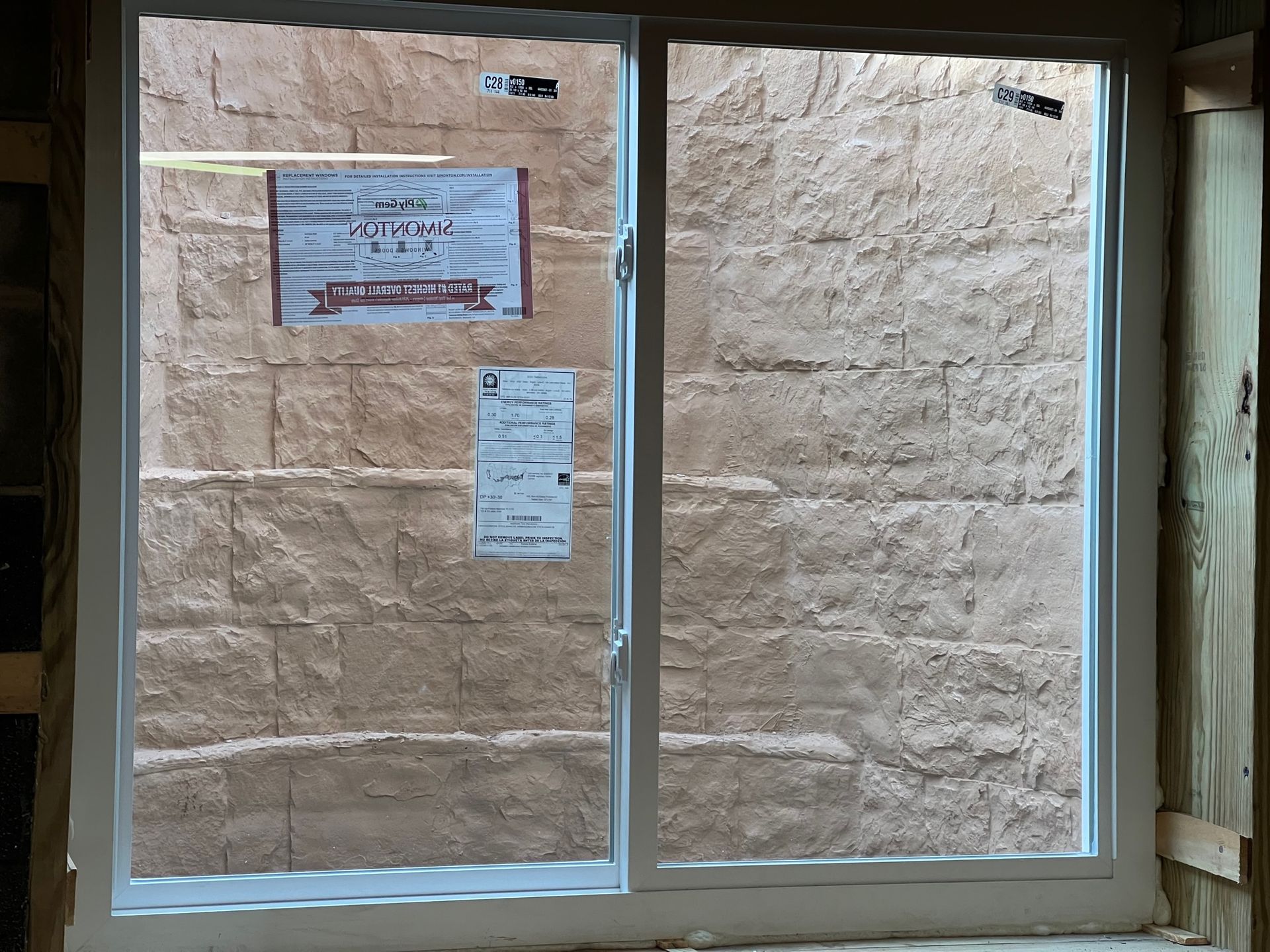 A window is sitting in front of a brick wall.