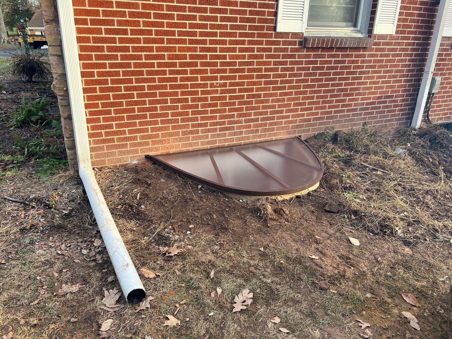 A brick house with a drain pipe next to it.