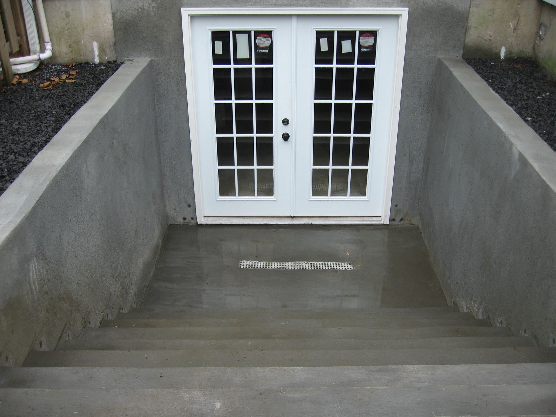A concrete staircase leading to a basement door